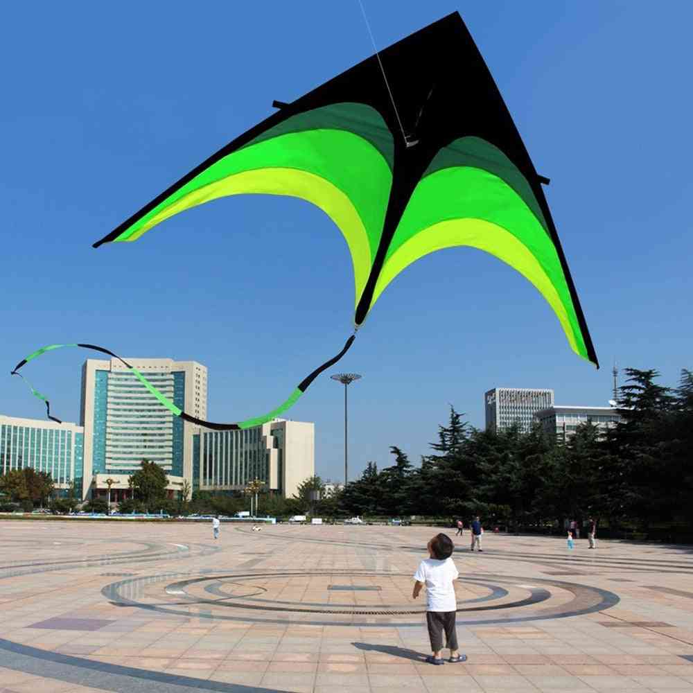Super große Kinder, die Drachen mit langem Schwanz für Spaß und Sport im Freien fliegen -